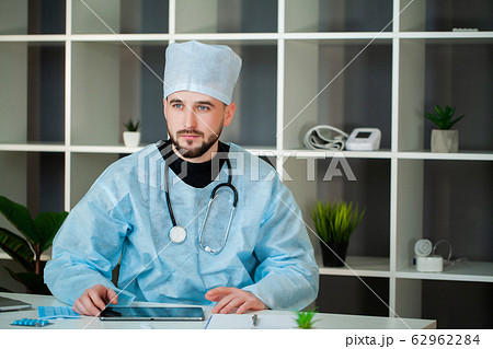 Doctor works at a table in the clinic's office. 62962284