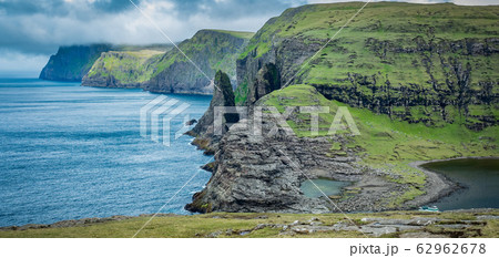 Steep coastline panorama in Faroe Islands with large boulders 62962678