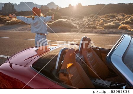 Woman traveling by car on a desert valley 62965358