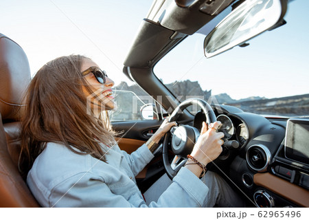 Woman traveling by cabriolet on the desert road Woman traveling by cabriolet on the desert road 62965496