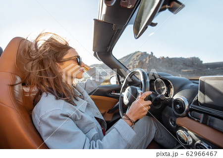 Woman traveling by cabriolet on the desert road 62966467