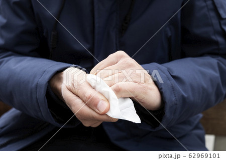 man disinfecting his hands with a wet wipe 62969101