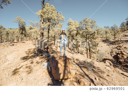 Woman hiking in the forest highly in the mountains on a volcanic rocks 62969501