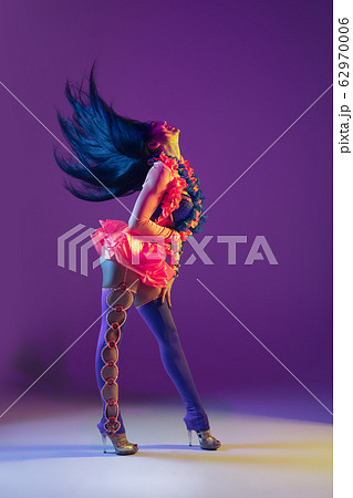 Attractive hawaiian brunette model on purple studio background in neon light 62970006
