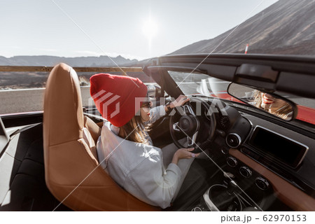 Woman traveling by cabriolet car on the desert road Woman traveling by cabriolet car on the desert road 62970153