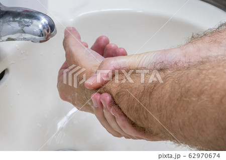 Man washing hands in basin close-up 62970674