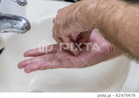 Man washing hands in basin close-up Man washing hands in basin close-up 62970676