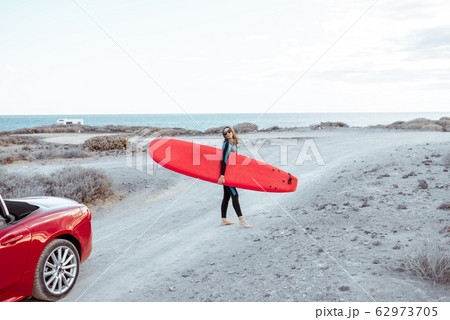 Woman with surfboard on the coast 62973705