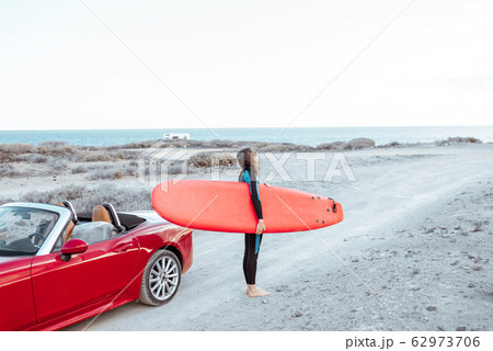 Woman with surfboard on the coast 62973706