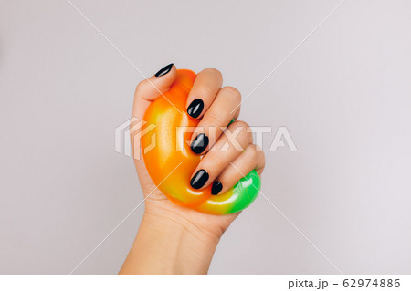 hands with black manicure holding slime 62974886