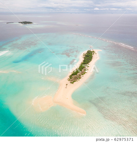 Picture perfect beach and turquoise lagoon on small tropical island on Maldives Picture perfect beach and turquoise lagoon on small tropical island on Maldives 62975371