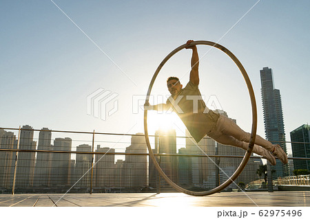 Cyr Wheel artist with cityscape background of Dubai during sunset 62975496
