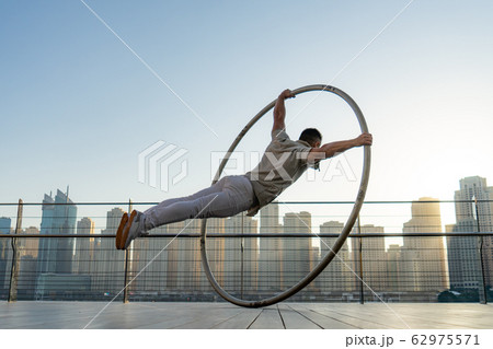 Cyr Wheel artist with cityscape background of Dubai during sunset Cyr Wheel artist with cityscape background of Dubai during sunset 62975571