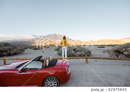 Woman traveling by car on the volcanic valley Woman traveling by car on the volcanic valley 62975645