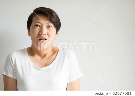 A woman portrait in an expression of stunned, frightened and panic on white background. 62977081