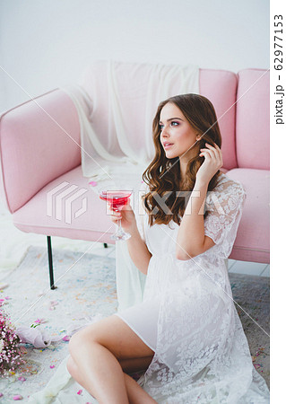 Close-up portrait of young beautiful model with with glass of rose drink Close-up portrait of young beautiful model with with glass of rose drink 62977153