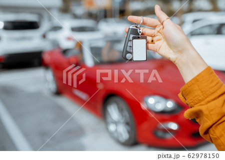 Woman holding keychain at the car parking Woman holding keychain at the car parking 62978150