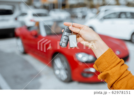 Woman holding keychain at the car parking Woman holding keychain at the car parking 62978151