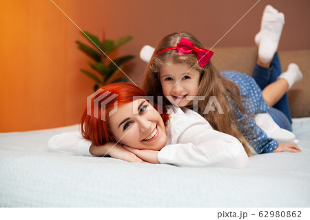 Mom and daughter resting in bed at home 62980862