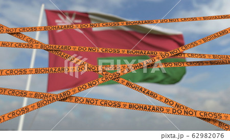 Biohazard restriction tape lines against the Omani flag. Restricted entry or quarantine in Oman. Conceptual 3D rendering 62982076