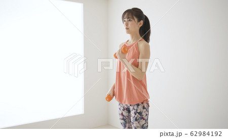 筋肉トレーニングをする若い女性　アームカール	 62984192