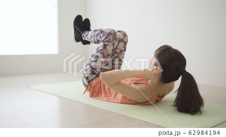 筋肉トレーニングをする若い女性 ツイストクランチ 筋肉トレーニングをする若い女性 ツイストクランチ 62984194