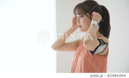 ウェアラブルデバイスを操作する若い女性 ウェアラブルデバイスを操作する若い女性 62984264