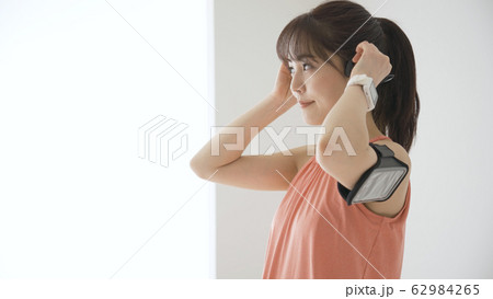 ウェアラブルデバイスを操作する若い女性 62984265