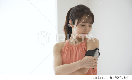 ウェアラブルデバイスを操作する若い女性 62984266