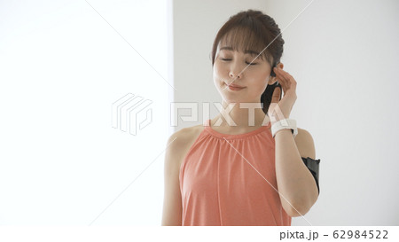 ウェアラブルデバイスを操作する若い女性 62984522