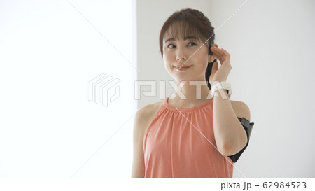 ウェアラブルデバイスを操作する若い女性 62984523