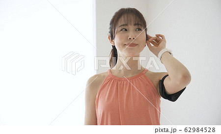 ウェアラブルデバイスを操作する若い女性 62984528