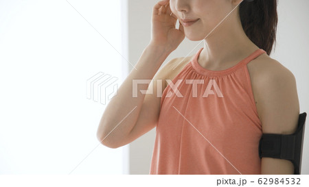 ウェアラブルデバイスを操作する若い女性 62984532