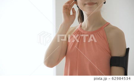 ウェアラブルデバイスを操作する若い女性 62984534