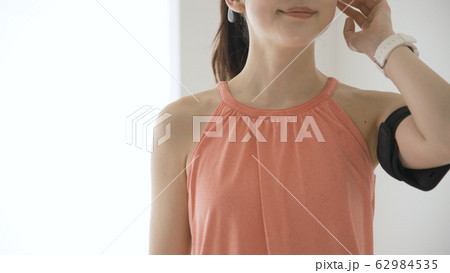 ウェアラブルデバイスを操作する若い女性 62984535