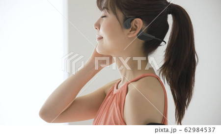 ウェアラブルデバイスを操作する若い女性 62984537