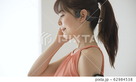 ウェアラブルデバイスを操作する若い女性 62984538