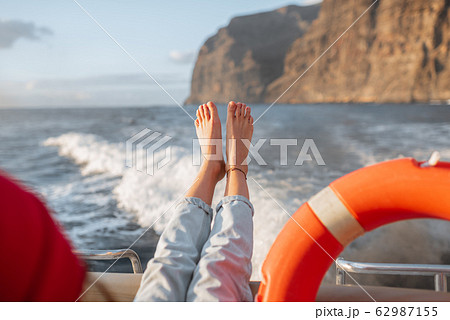 Woman sailing near the rocky coast 62987155