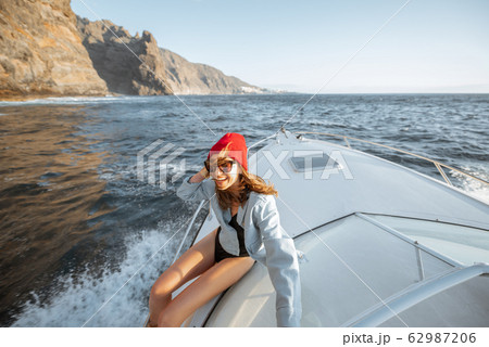 Woman sailing near the rocky coast 62987206
