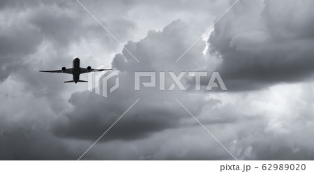 Airplane flying on dark sky and white clouds. 62989020