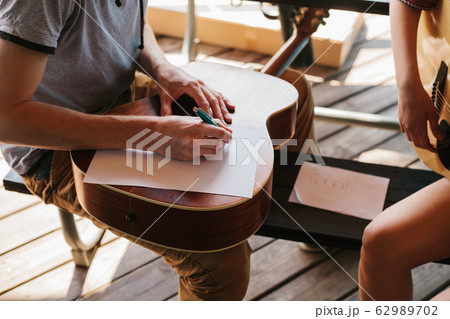 Learning to play the guitar. 62989702