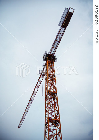 Big tower crane against a cloudy sky Big tower crane against a cloudy sky 62990133