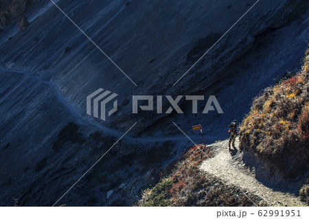 Trekker walking on mountain with mountains Trekker walking on mountain with mountains 62991951