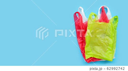 Colorful plastic bags on blue background. Colorful plastic bags on blue background. 62992742