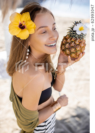 Summer girl with pineapple fruit at the beach resort Summer girl with pineapple fruit at the beach resort 62993047