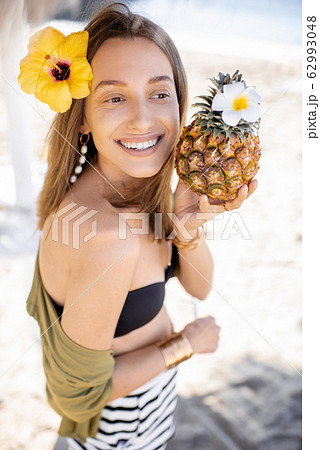 Summer girl with pineapple fruit at the beach resort Summer girl with pineapple fruit at the beach resort 62993048