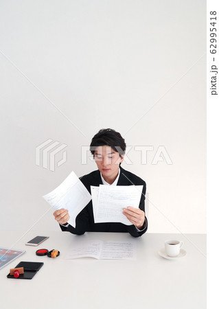 契約書と資料を精読するビジネスマン 契約書と資料を精読するビジネスマン 62995418