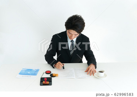捺印するビジネスマン 62996583