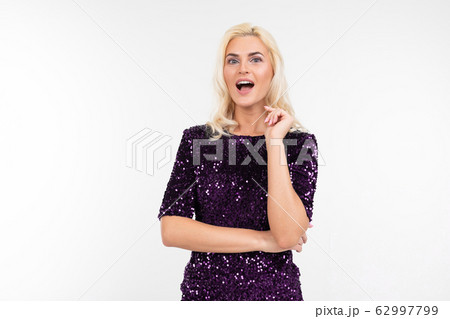 charming surprised blonde girl in purple beautiful elegant dress on a white background with copy 62997799