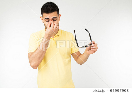guy feels pain in his eyes removing his glasses for vision on a white background 62997908